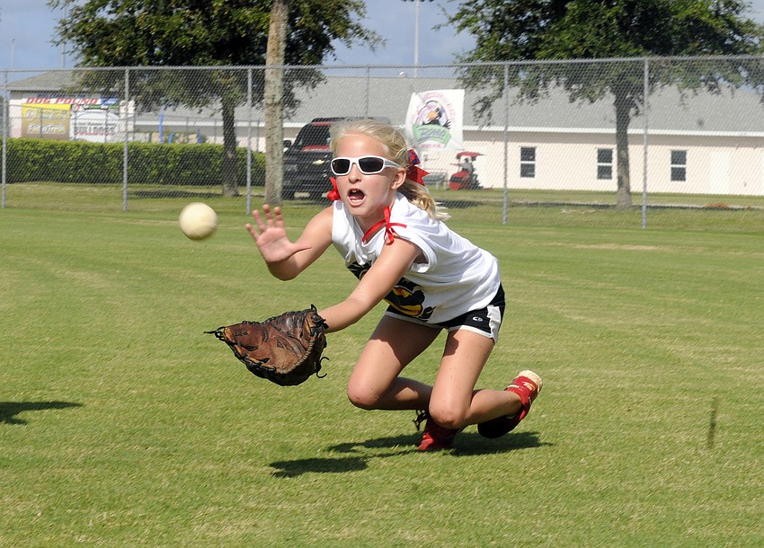Eight-year-old Rylee Miller dives for a fly ball.