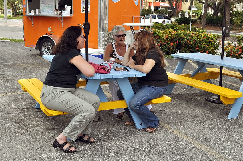 Bonnie Hammer, Judy Winslow and Brenda Smoak sit on the newly painted and shaded picnic benches while waiting for their food Tuesday, Sept. 11 at Ringling Picnic.