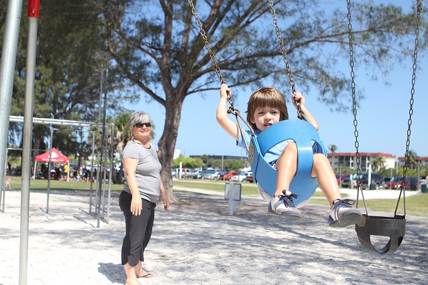 Gail Donovan pushes her grandson, Niccolo Aretini, 4, on a swing.