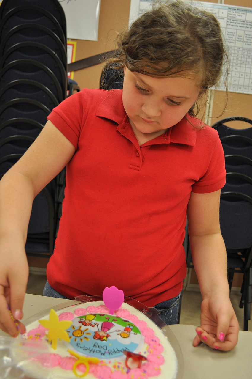 Nataly Durazo, 9, tastes a few sprinkles as she decorates.