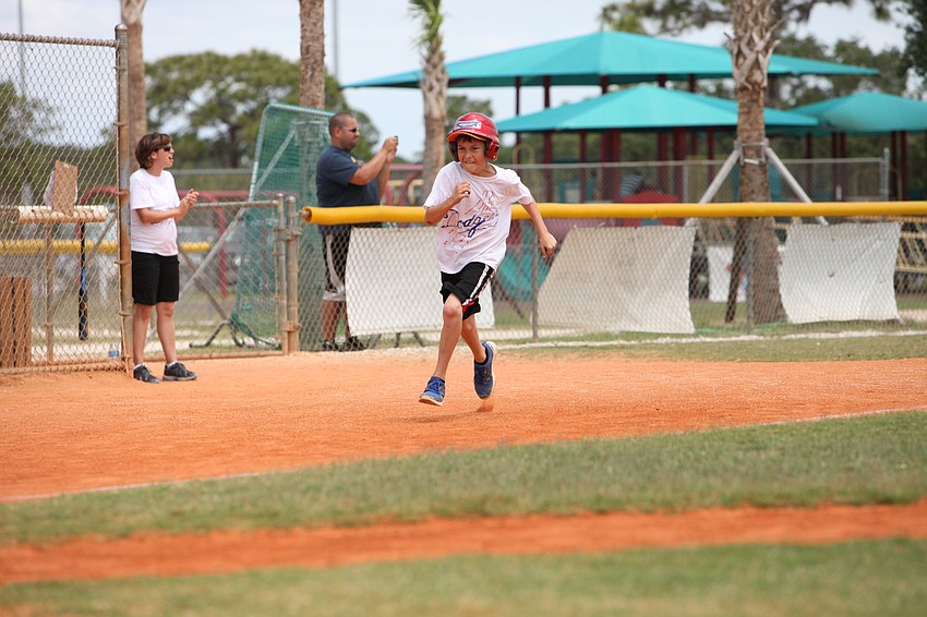 RJ McLaughlin rounds third base and heads towards home plate.