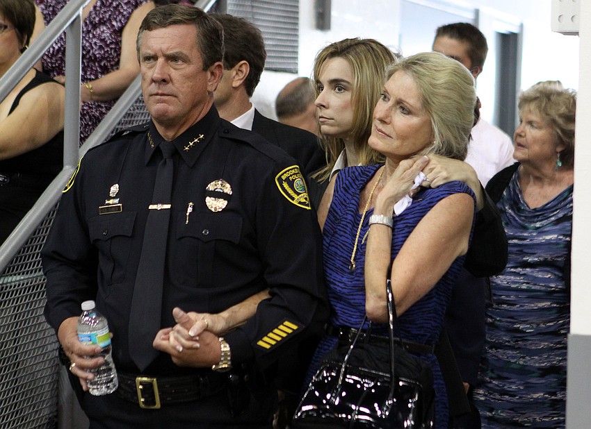Leslie Hogle reaches back to hold her daughter, Sandy's, hand prior to the beginning of the ceremony Thursday, May 24, at Robarts Arena.