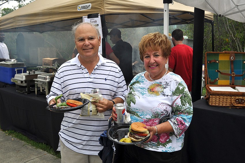 Steven Cohen and Helen Katz get hamburgers from the Mattisonâ€™s booth, Friday, June 8, during Friday Fest at the Van Wezel.