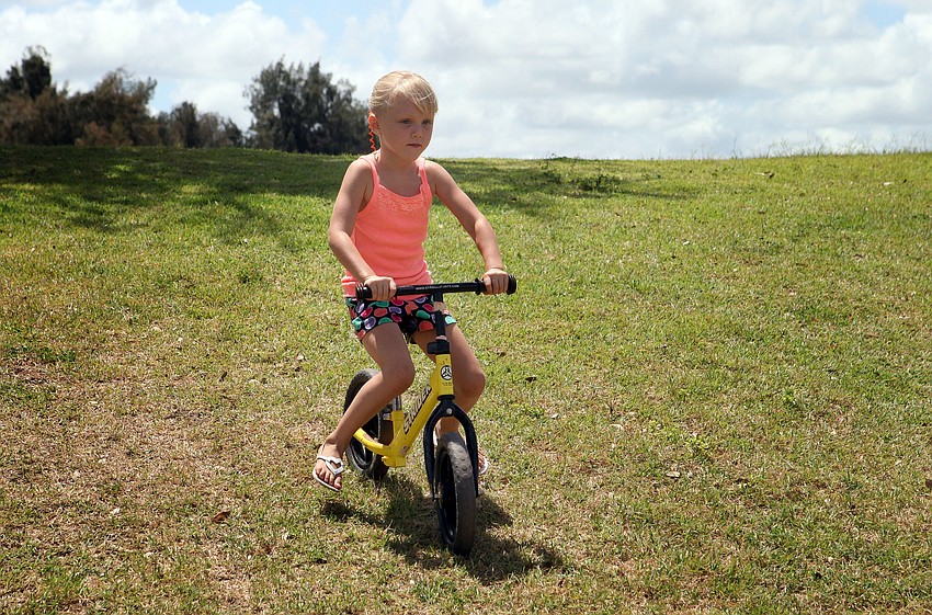 Katelyn Bentley, 6, rides down the hill on a Strider bike, Saturday June 16, during the Sarasota Sports Festival at Payne Park.