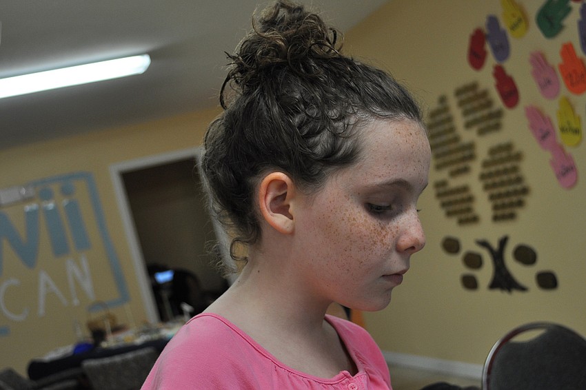 Gloria Wieand, 11, looked at her flower arrangement from several angles.