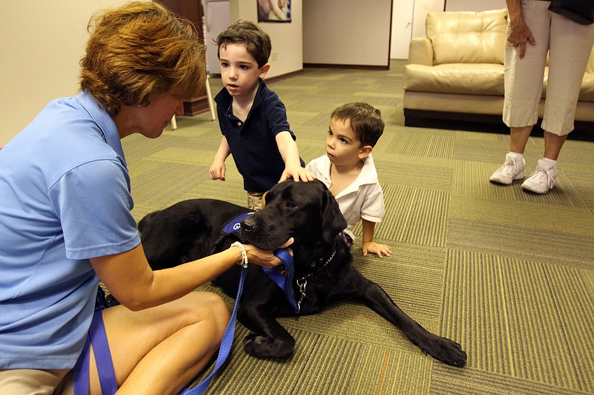 Sue Tomasso talks to Carlo, 4, and Xavier, 3, Pantone while they pet Frela, Saturday, July 21, during Puppy Love at Southeastern Guide Dogs Sarasota.