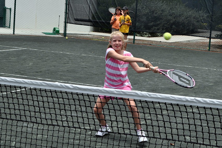 Alexia Pasold, 8 Â½, goes to hit a backhanded volley during tennis drills on Monday afternoon.