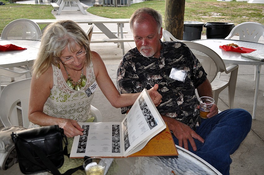 Robyn Anderson Cobb looks through one of the high school yearbooks with her husband, Ty, Friday, Aug. 3, at the Sarasota Sailing Squadron.