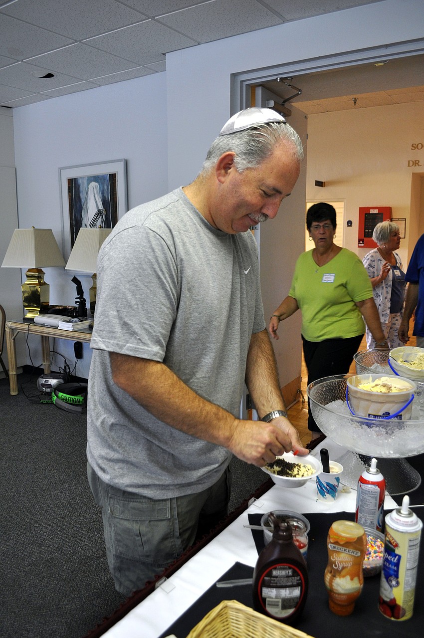 Jeff Weiss adds a cherry to the top of his sundae.