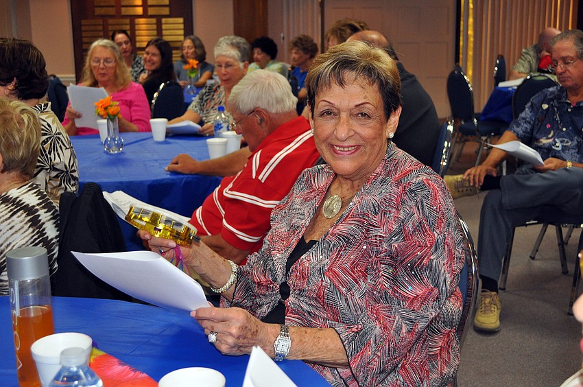 Marjorie Rosenthal smiles while playing the tambourine.