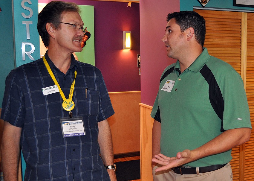 Larry Hale and Seth Adkins talk to one another at the Daiquiri Deck on St. Armands.