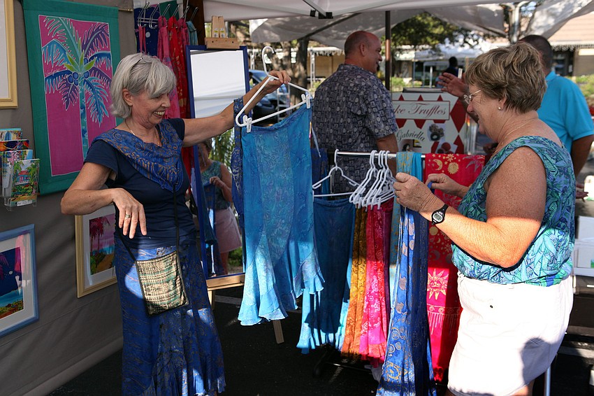 Rita Van Gorder shows the difference between skirts to Dottie Schell Sunday, Sept. 1 at the Siesta Key Farmers Market. Van Gorder