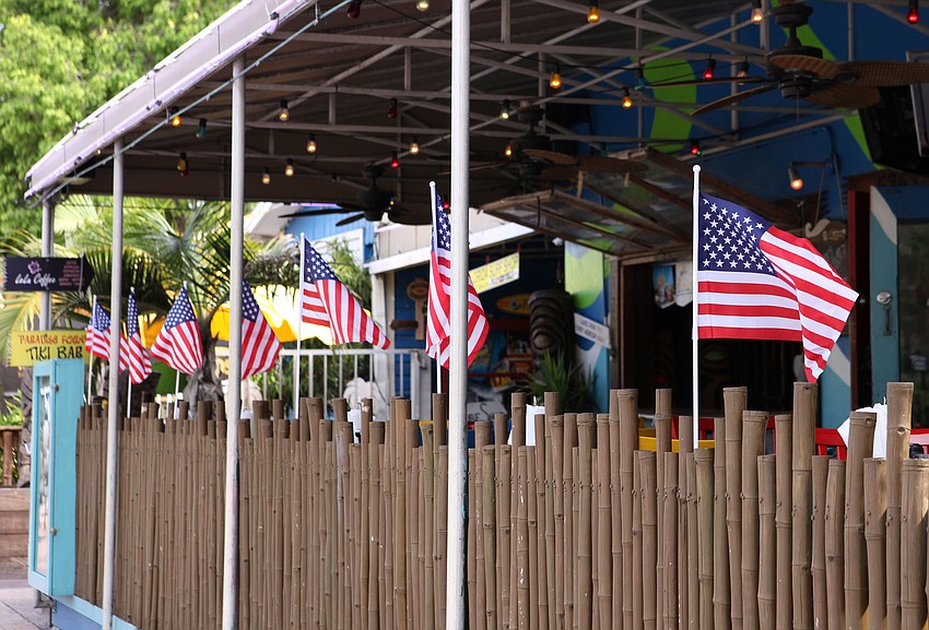 American flags line the front gate of Gilligan's.