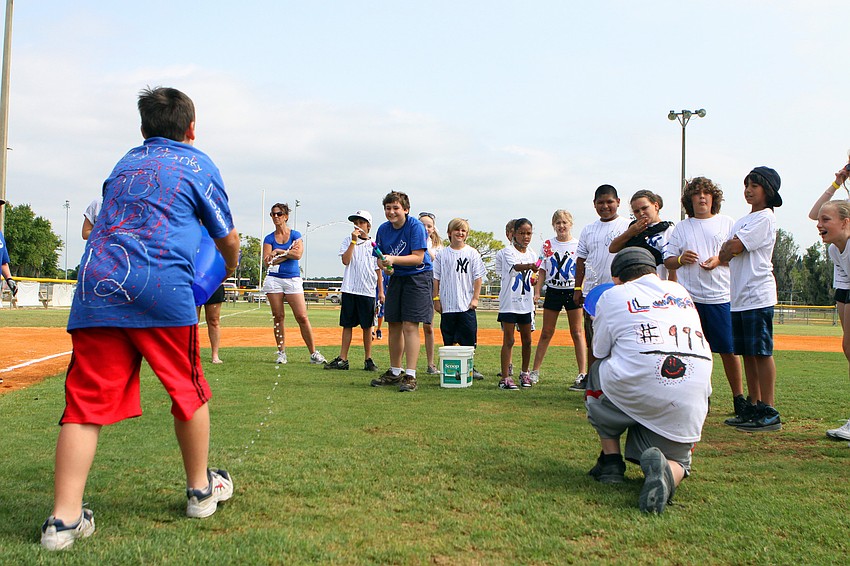 Nico Fochi and Delyla Rodgers squirt water at buckets held by Zachary Lunsmann and Jesse Auricchio during one of the many games played inbetween innings Friday, April 29 during the Ashton Elementary fifth grade World Series day at Twin Lakes.