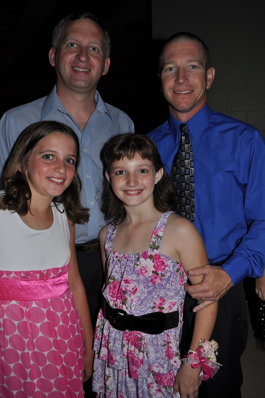 Cousins Bethany Kruger and Savannah Moreland enjoy the night with their fathers, Randy Kruger, left back, and Brian Moreland, right back.