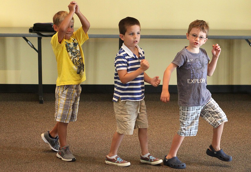 Michael Fesko, Liam Lizotte and Chance McCarter march around the room in a circle.
