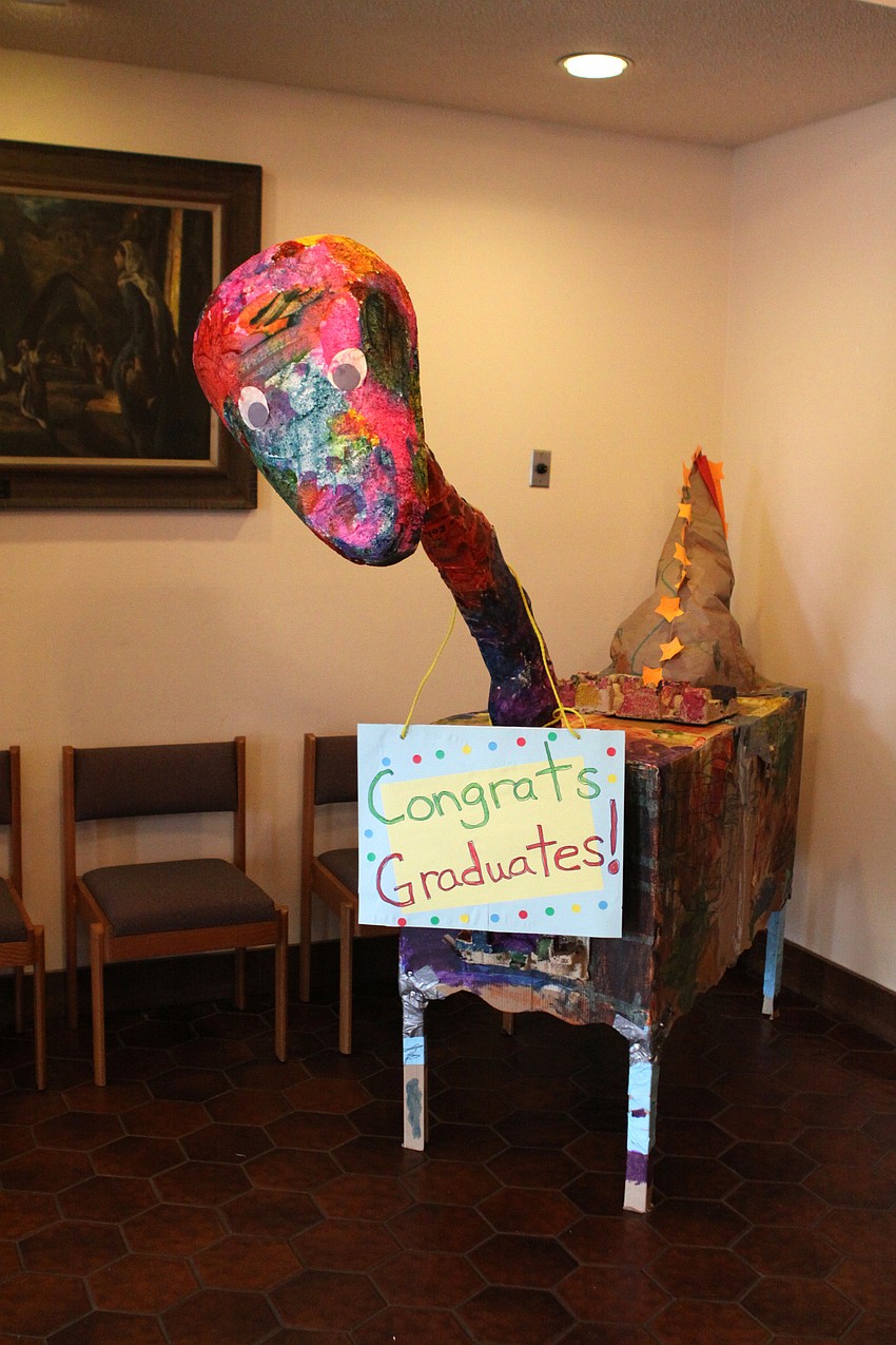 Rectanuglarsaurus wore a sign that said â€œCongrats Graduates!â€ inside the church.