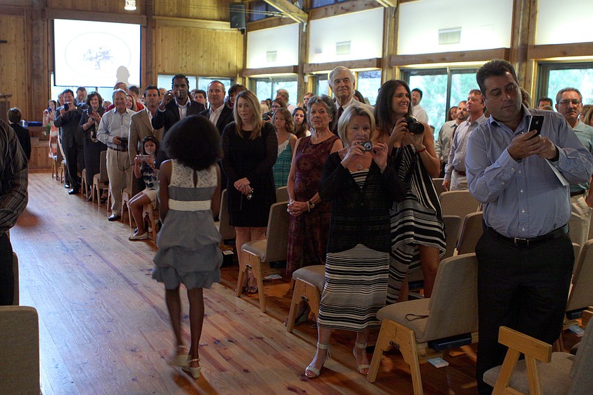 Family members of the graduates take photos and smile at the students as they make their way into Siesta Key Chapel for graduation, Friday, June 1.