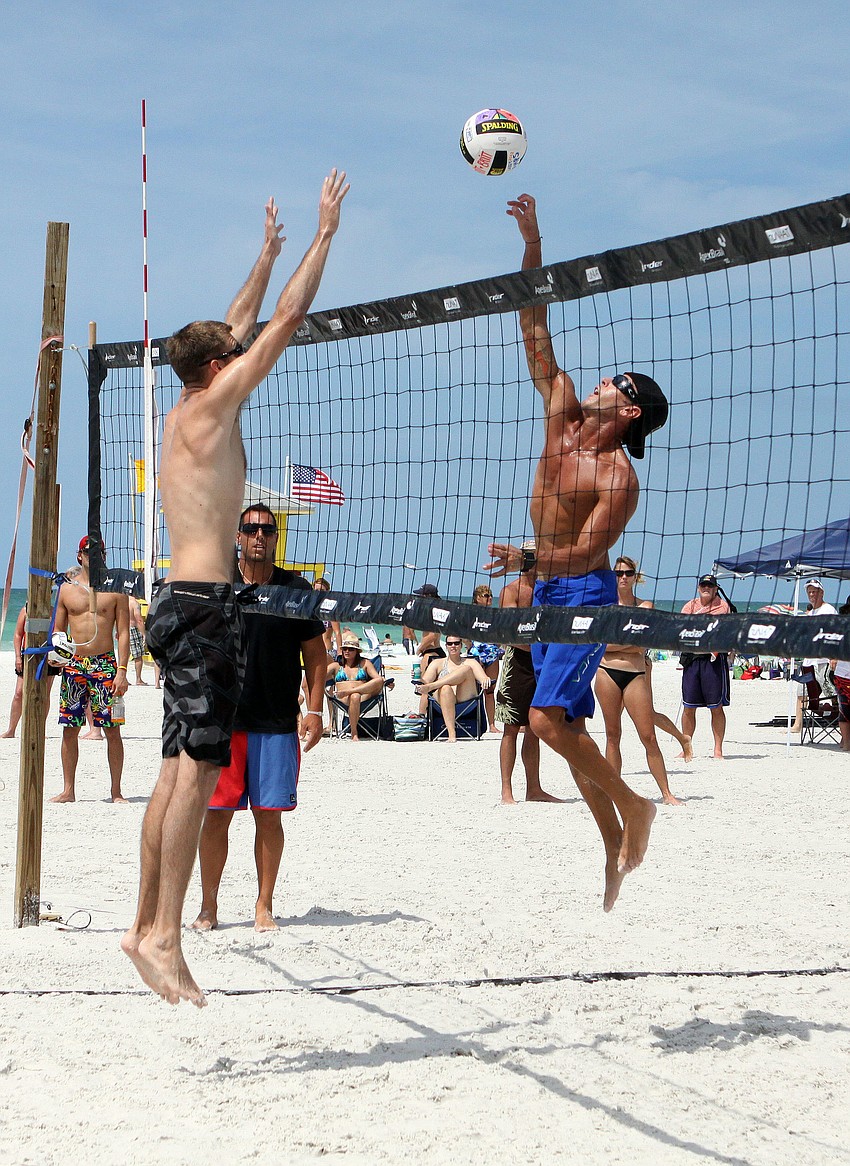 Roger Corvitt hits the ball over the net at Garrett Rasmussen.