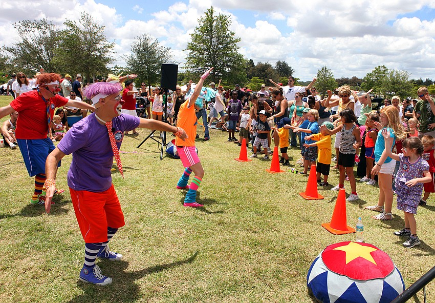 Clowns from Ringlingâ€™s Barnum and Bailey Circus lead kids and their parents in some fun stretches, Saturday June 16, during the Sarasota Sports Festival at Payne Park.