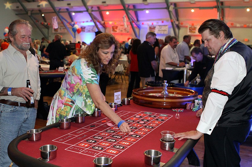 Shelly Brown has fun playing Roulette as her husband, Daniel, looks on, Saturday, June 23, at the Festival Kickoff Party for the 2012 Suncoast Super Boat Grand Prix Festival at the Sarasota Municipal Auditorium.