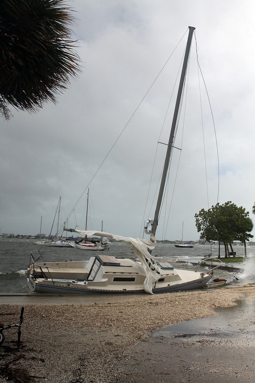 A sailboat was tipped over and into the concrete barrier at Island Park.