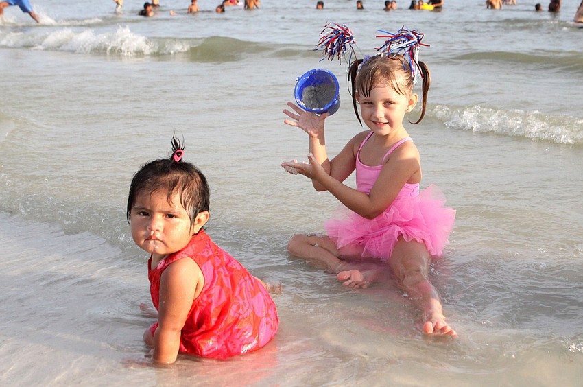 Jasmine Lopez, 1, and Athena Coughlan, 4, have fun playing in the water at the shoreline, Wednesday, July 4, at Siesta Key Public Beach.