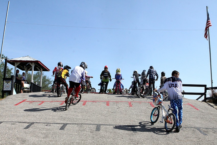 Race participants make their way up the hill to get some practice on the race course prior to the Olympic Day races, Saturday, July 7, at Sarasota BMX.