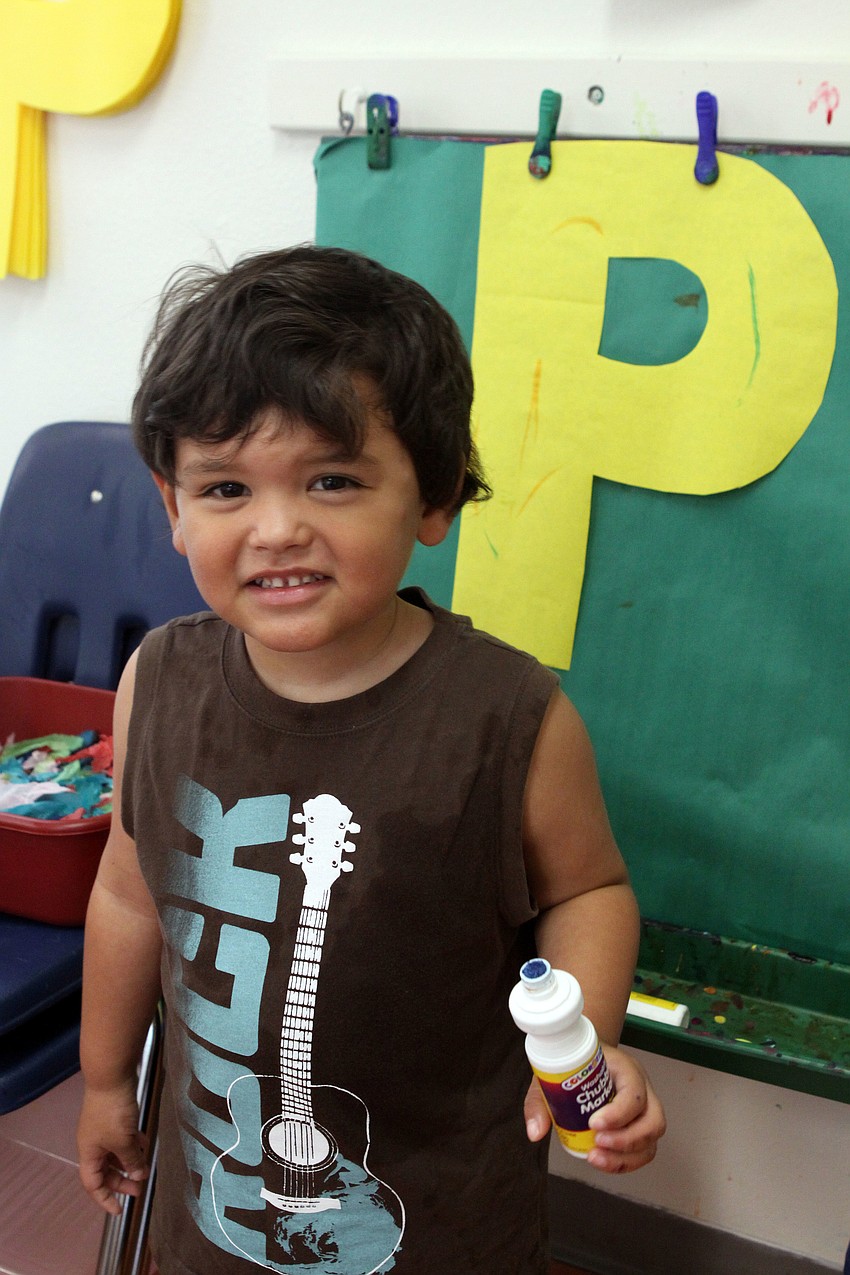 Victor Gomzalez, 3, paints polka dots on a yellow â€œPâ€, for penguin.