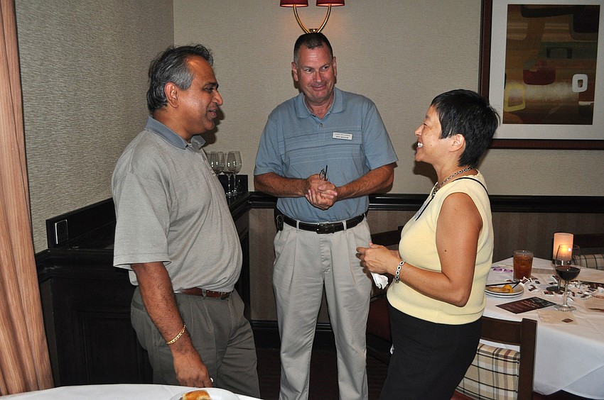 Loyola Dâ€™Sa, Ron Bognar and Fay Huang have fun talking to one another at the business card exchange on Thursday, July 19, at Ruthâ€™s Chris Steak House.
