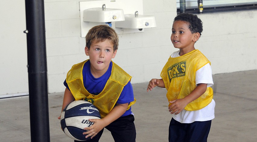 Six-year-old Jack Meyers goes up for a shot as five-year-old teammate Mason Ackerman looks on.