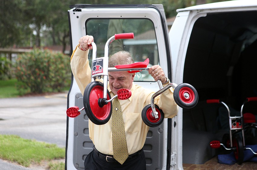 Dr. Jacques Esclangon, President of the Rotary Club of Sarasota Bay Foundation, unloads one of the new tricycles, Tuesday, Aug. 7, at Pines of Sarasota.