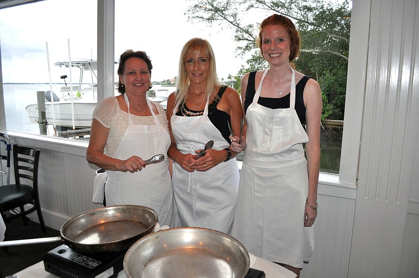Debra Campion, Tami Richards and Courtney Dougherty prepare to cook during Pattigeorgeâ€™s Interactive Dinner, Friday, Aug. 17.