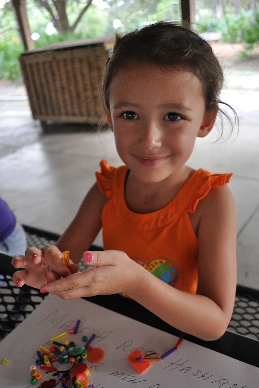 Lily Scholsberg, 4, makes a bracelet.