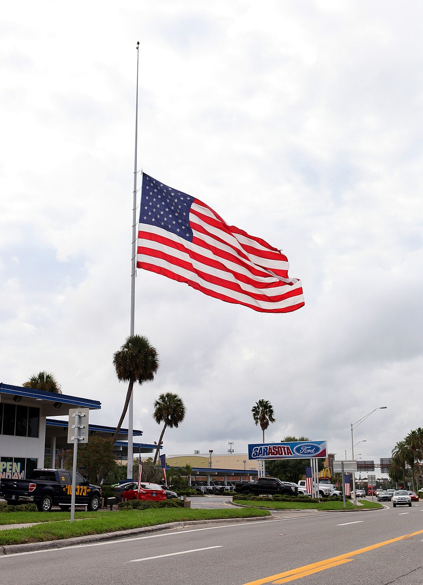 The large American flag at the Sarasota Ford dealership is at half-mast.