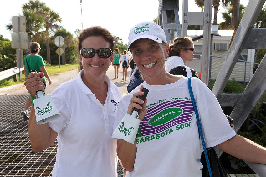 Charlotte Hinman and Paula Davenport cheer on the Scullers and other rowers as they go under the bridge.