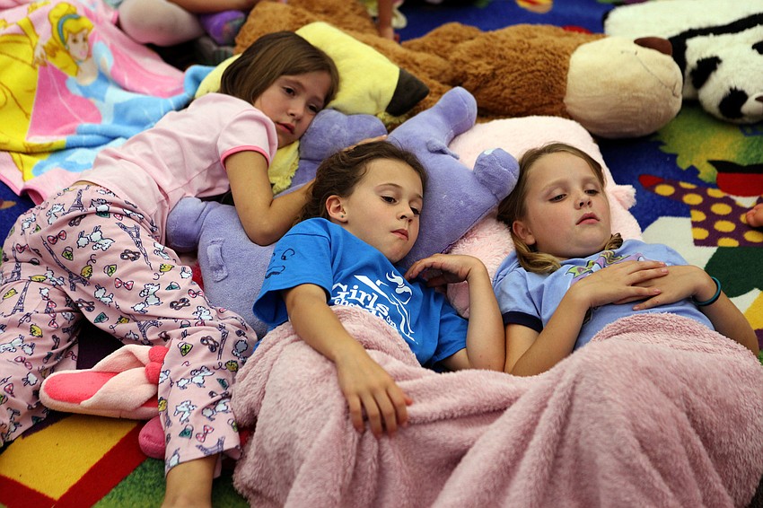 Anita Hrncic, 7, Sally Koscho, 7, and Kate Kochis, 7, made themselves comfortable while they listened to one of the stories being told during Phillippi Shoresâ€™ storybook and PJ night, Thursday, April 26.