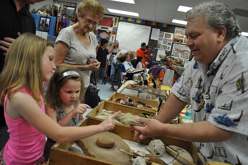 Walter Hodgdon, right, shows off Native American artifacts to Ella Miller, front, and her sister, Taylor, behind.