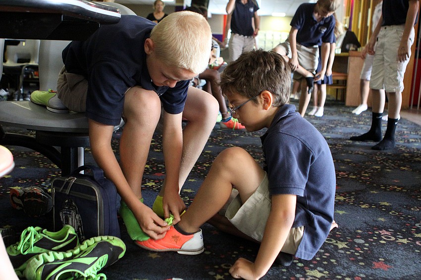 Taber Chadwick, 12, helps his buddy Pedro Princeno, 7, Friday, May 18, at Sarasota Lanes.
