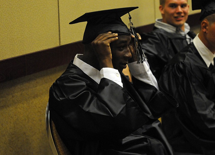 Demond Bradley adjusts his cap before the start of Braden Riverâ€™s commencement ceremony.