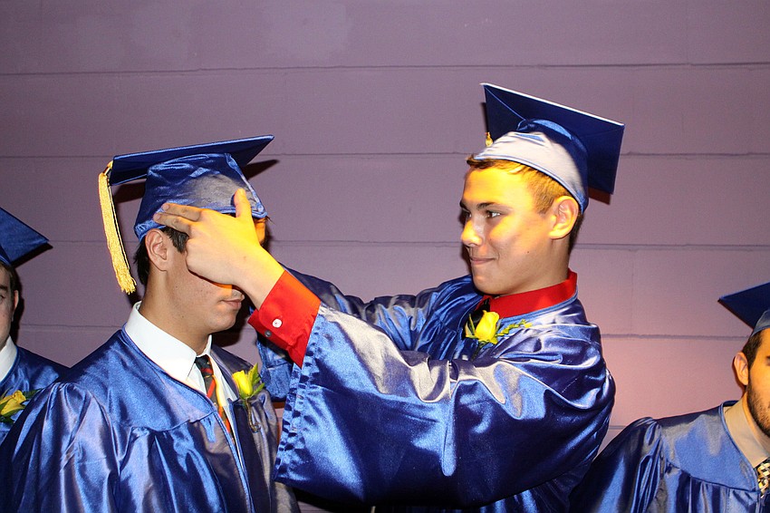 Nick Corizzi gets some help with his cap from Jason Conway.