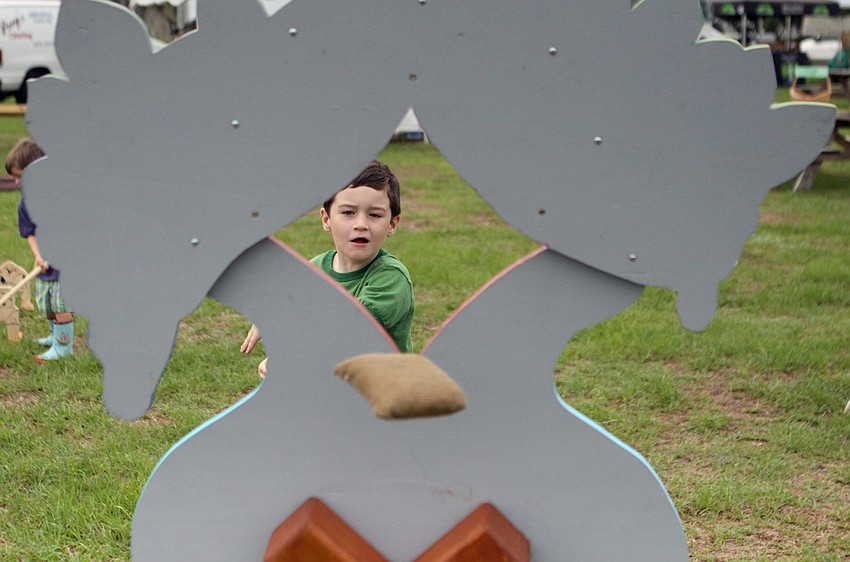 Grant Burroughs, 6, threw a beanbag through a wooden bird cut out.