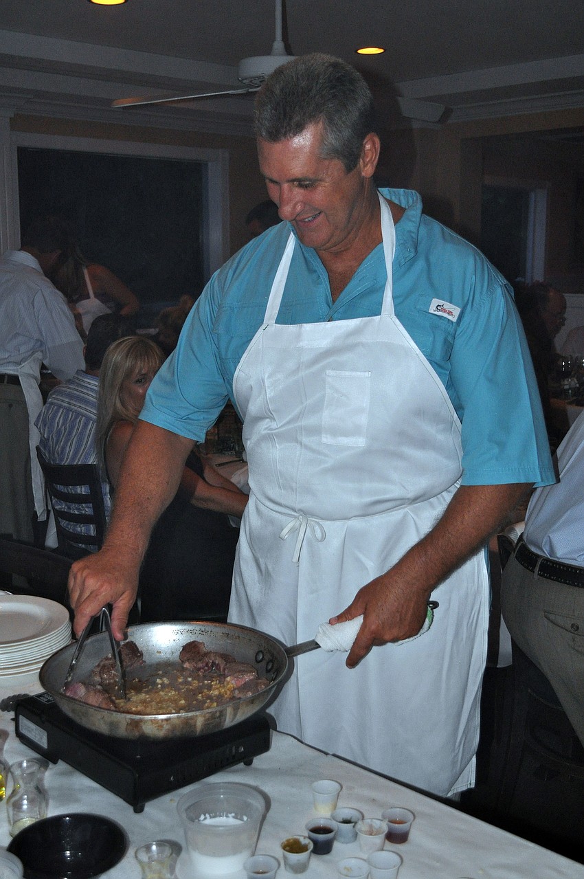 Ron Barcena gets cooking during Pattigeorgeâ€™s Interactive Dinner, Friday, Aug. 17. The theme was Taste of the World with dishes inspired by India, Thailand, Greece and France.