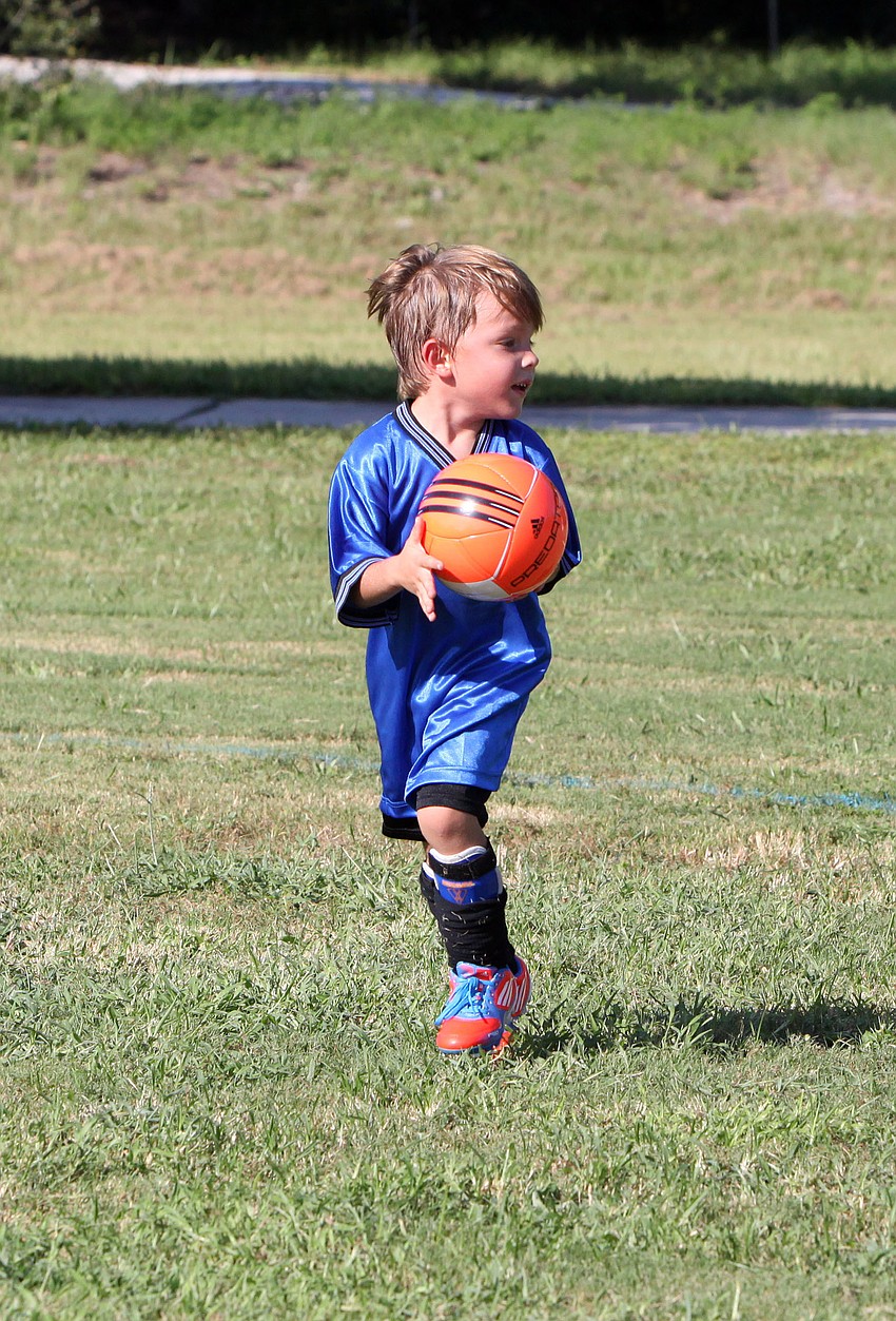 Tre Liszewski, 3, has fun running around after his game with his orange soccer ball at Glebe Park.