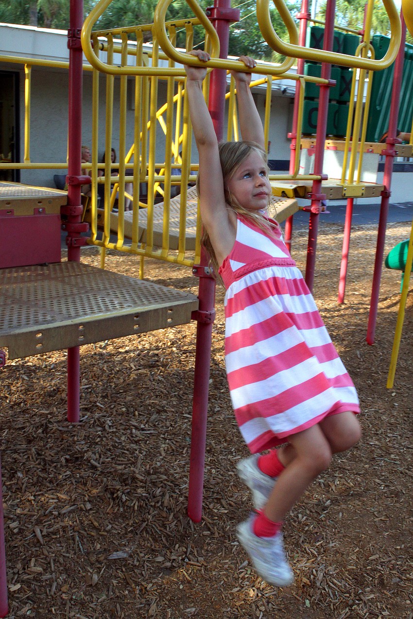 Katy Fulton, 5, has fun on the monkey bars.