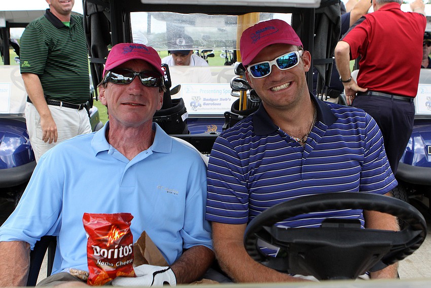 Dave Egan and Richard Campbell enjoy their brown bag lunches in their cart.