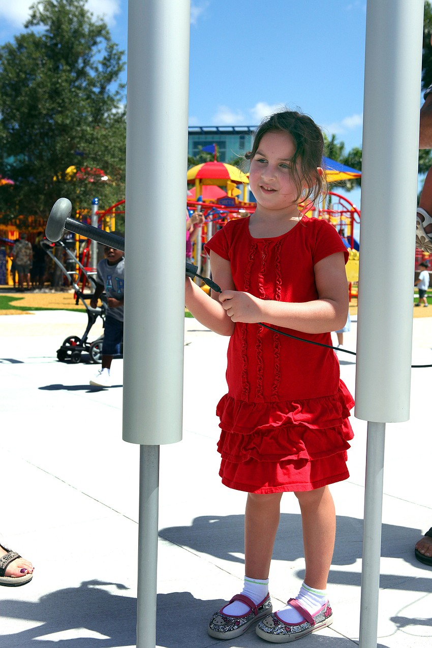Ella Collier, 5, has fun ringing the chimes at the new playground at Payne Park.