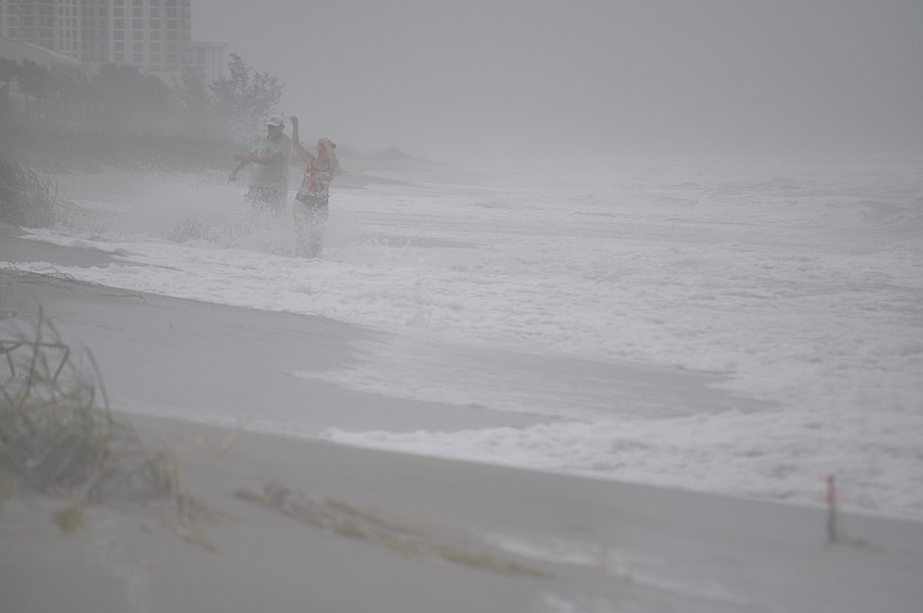 Two vacationers didn't let Debby get in the way of their day at the beach Monday. Dangerous person-high waves were crashing into the beach.