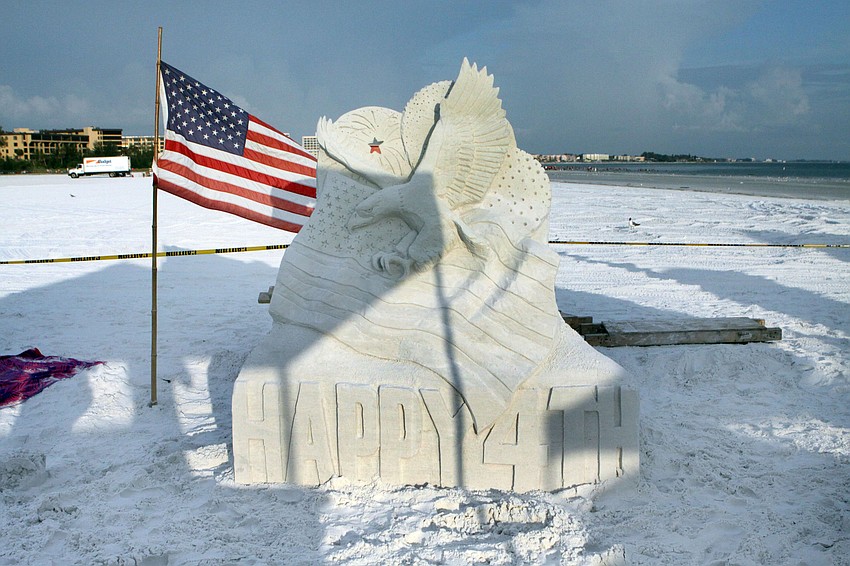 A sand sculpture including fireworks, a Bald Eagle, an American flag and a carved out 