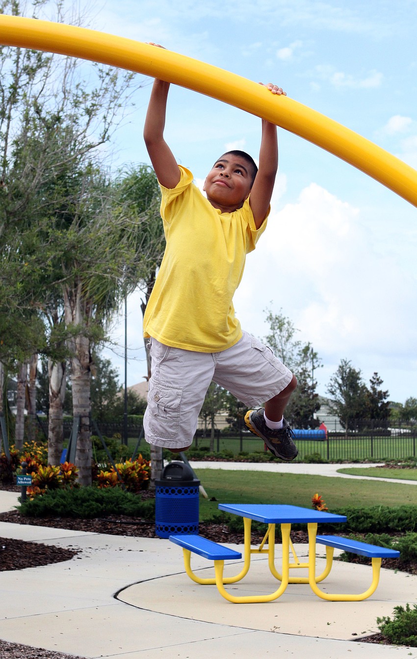 Nathaniel Garcia, 8, swings from a pole at Central Park playground, Wednesday, July 18.